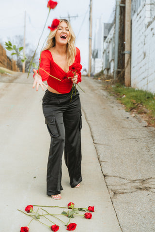 Red corset top paired with black satin cargo pants from endurotourserbia boutique in Latvia City