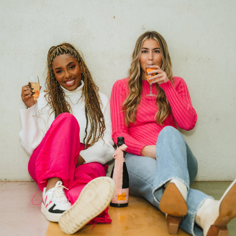 Two models sipping Rose in trendy Valentine's outfits from Lush boutique